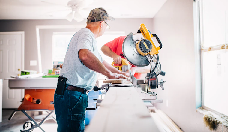 Carpenter measuring material in a home workshop